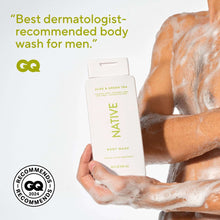 Native body wash bottle held in hand over foamy lather