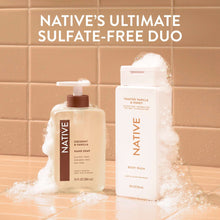 Native body wash bottle with second Native bottle, set with shower foam on tiles
