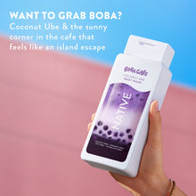 Coconut Ube body wash bottle held in hand with purple label and beads graphic