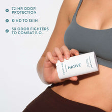 Native deodorant stick held in hand, white tube with teal logo