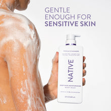 Person holding Vanilla & Cashmere moisturizing body wash bottle with purple pump.