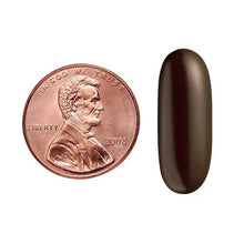 Magnesium softgel capsule next to copper-colored coin for size reference