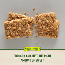 Crunchy oats 'n honey granola bar pieces on a plain surface