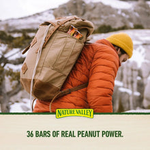 Nature Valley granola bars branding on tan backpack with orange jacket, outdoors.