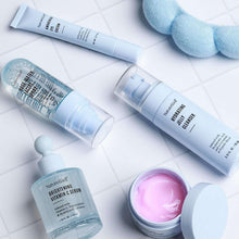 NatureWell skincare products on white tiles: tube, spray can, jar, and open cream pot