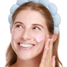 Hydrating skincare serum mist being dabbed under the eye on a smiling person