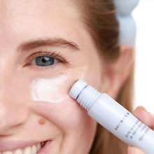 Brightening serum being applied with a white-and-blue squeeze dispenser onto face
