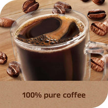Glass mug of dark coffee with foam and scattered coffee beans