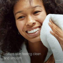 Face cleanser results, person smiling while wiping off creamy white foam with towel