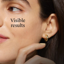 Night cream application near ear with fingertip, close-up model face