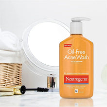 Oil-free acne face wash bottle with white pump beside towel and sink items