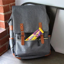Gray backpack with a Newtons fig cookie pack clipped to the front