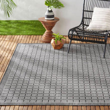 Geometric indoor outdoor area rug with gray and dark grid squares, flat woven look