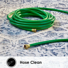 Outdoor rug surface with blue distressed pattern beneath coiled green garden hose