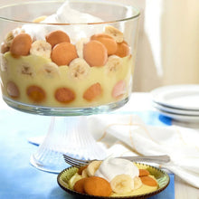 Vanilla wafer cookies in a glass bowl with white cream and fruit pieces