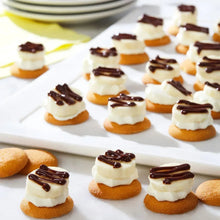 Vanilla wafer cookies topped with white cream and chocolate drizzle