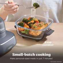 Glass baking dish style container on air fryer base with herbs and vegetables
