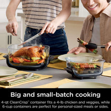 Portable air fryer with glass container in use as food is lifted with tongs