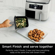 White dual-basket air fryer with basket pulled out showing vegetables
