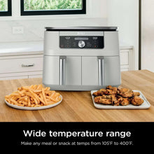 White dual-basket air fryer on a counter with dual handles