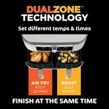 Dual-zone air fryer with two cooking baskets showing chicken and vegetables, white