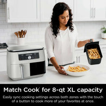 White dual-basket air fryer with one basket removed and food inside
