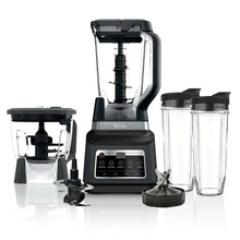 Kitchen blender base with clear pitcher, slicing drum, and food processing accessories