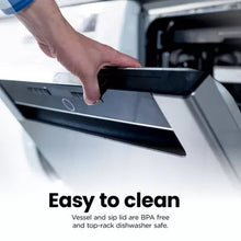 Cordless personal blender base with black top, being wiped clean by a hand