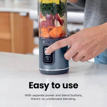 Cordless personal blender on countertop with finger pressing start button