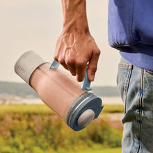 Hand operating a tumbler blender lid on a cup, with blue base and straw top