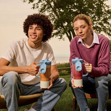 People holding tumbler blender cups with lids and straws, blue and red containers