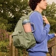 Person carrying a blue tumbler blender cup with lid, outdoors