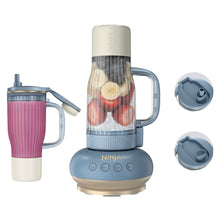 Tumbler blender with clear cup, fruit inside, blue base, handle and lid caps