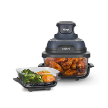 Portable air fryer system with glass cooking container holding cooked chicken