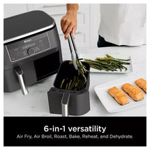 Dual-basket air fryer with a loaded basket pulled out, black finish