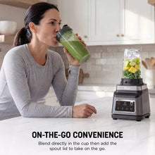 Blender with on-the-go cup and pitcher, green smoothie served near stainless base