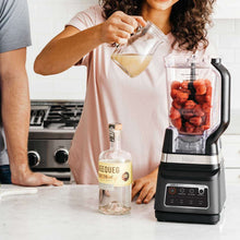 Ninja blender DUO blending pitcher with fruit inside and black base on countertop