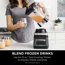 Ninja blender DUO pouring orange smoothie into a clear cup