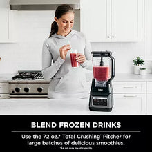 Countertop blender with red blend in clear pitcher and black base