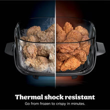 Clear cooking basket in portable air fryer filled with coated fried bites