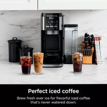 DualBrew coffee maker with carafe and two iced coffee cups on countertop