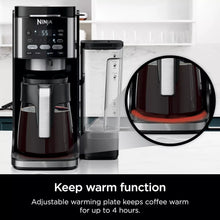 DualBrew coffee maker with carafe, clear pod reservoir, and warming plate area view
