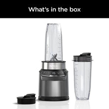 Personal blender base with clear blending jar, travel cup, and spare lid parts