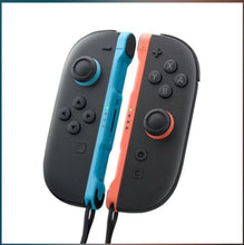 Joy-Con controllers close-up: black pads with light blue left and light red right accents