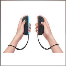 Joy-Con L/R controllers held in hands; left light blue rail, right light red rail