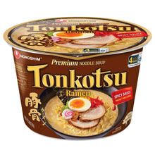 Tonkotsu ramen cup with spicy sauce packet and egg topping photo