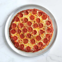 Round pizza pan with pepperoni pizza, thick crust and evenly spaced pepperoni circles