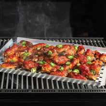 Perforated crisping tray on grill rack with roasted chicken wings topped with green onions