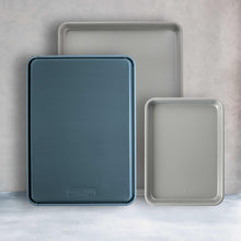 3-piece non-stick baking sheet set with blue and white trays, nested together