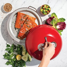 Red kettle smoker lid being closed over a seasoned salmon fillet
